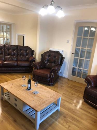a living room with leather couches and a coffee table at Lake View Retreat in Enniskillen