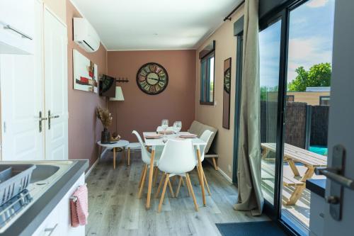 une salle à manger avec une table et des chaises et un balcon dans l'établissement Tiny T, 4 personnes Loches, proche zoo de Beauval, à Loches