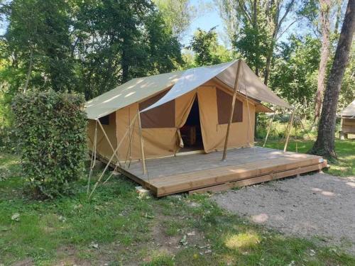 a tent with a wooden deck in a field at Camping 3 étoiles - ccaiaah in Monoblet