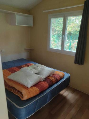 un lit assis dans une pièce avec une fenêtre dans l'établissement Camping 3 étoiles - ccaa0ib, à Sainte-Reine-de-Bretagne