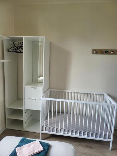 a white crib in a room with a mirror at L'Escale 3 Chambres Clermont-Ferrand in Clermont-Ferrand