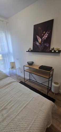 a bedroom with a bed and a table and a laptop at Apartament Burgund 2 pokojowy z ogródkiem lub pokoje ze wspólną kuchnią i łazienką in Warsaw