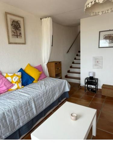 - une chambre avec un lit doté d'oreillers colorés et d'une table dans l'établissement Chez Jo Duplex Terrasse vue mer Hyères, à Hyères
