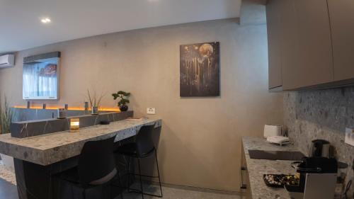 a kitchen with a bar with black bar stools at Boutique Moonlight Apartment in Kragujevac
