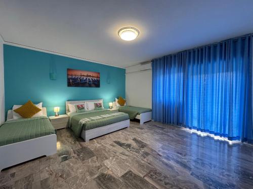 a bedroom with two beds and blue walls at venice popular residence in Mestre