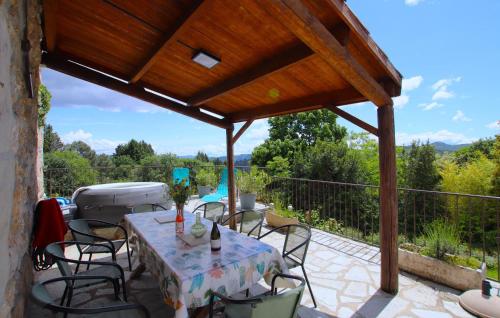 un patio con tavolo e sedie su un balcone di Demeure Romantique Le Pêcher a Pont-de-Labeaume
