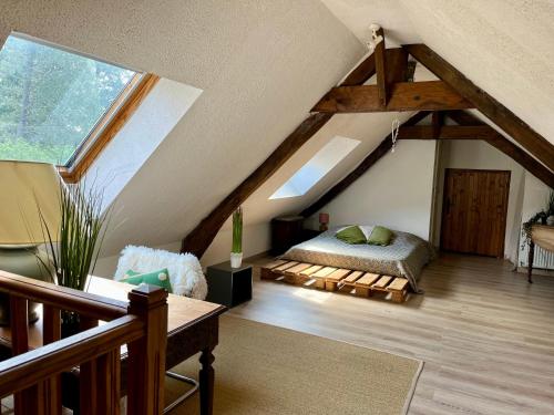 a bedroom with a bed in a attic at La petite maison in Saint-Mars-dʼOutillé