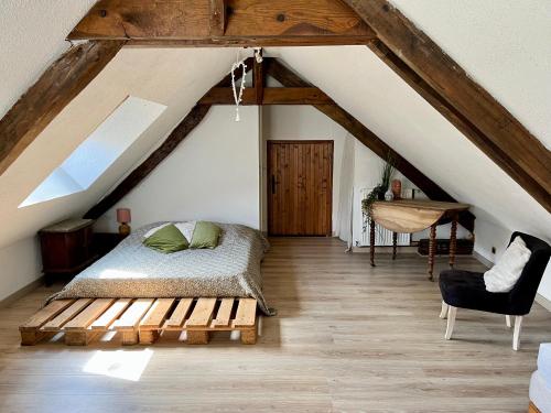 a bedroom with a bed and a wooden floor at La petite maison in Saint-Mars-dʼOutillé