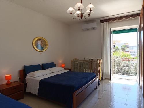 a bedroom with a blue bed and a large window at Le Rondini in Trani