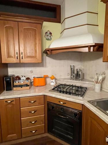 a kitchen with wooden cabinets and a stove top oven at B&b Carducci in Gorizia