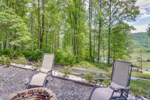 two chairs sitting on a fire pit in the woods at 4 Mi to Lake Santeetlah Cabin with Deck and Views in Robbinsville