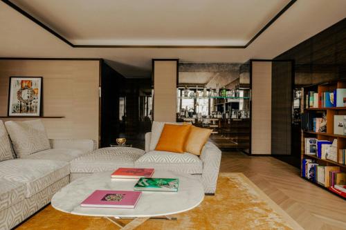 a living room with a couch and a table with books at Bvlgari Hotel Paris in Paris