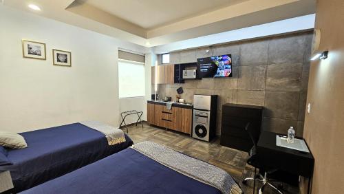 a hotel room with two beds and a tv at A22 SUITE BLACK MAX para 2 a 4 personas, Especialistas Cortas Medianas Largas Estancias, en IZCALLI TEPOTZOTLAN perfecto para Familias, Turistas, Contratistas, Estudiantes, Empresas A sólo 5 min Izcalli 5 min Esmeralda 20 min Satélite 25 min AIFA in Cuautitlán Izcalli