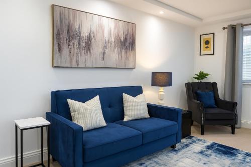 a living room with a blue couch and a chair at LuxeView - Stylish & Comfortable 1 Bedroom House in Chafford Hundred in North Stifford
