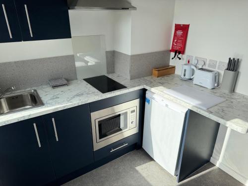 a kitchen with a sink and a microwave at Aaron Wise - 09 Coldstream Studios in Cardiff