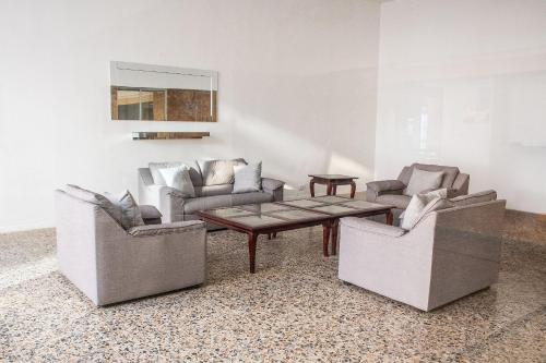 a living room with three chairs and a coffee table at Ocean view - 77Rentals in Cartagena de Indias