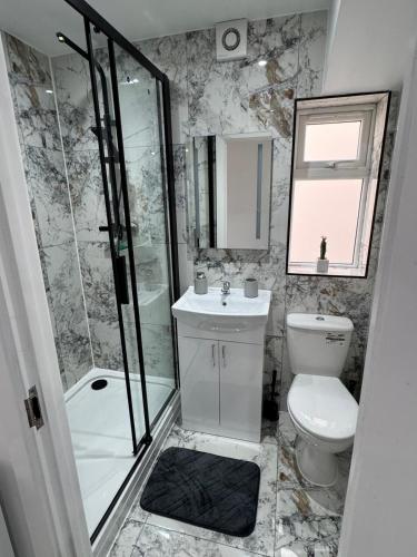 a bathroom with a toilet and a shower and a sink at Near Birmingham - Stylish and Peaceful - Private Parking in Birmingham