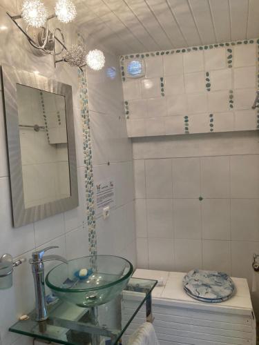 une salle de bain avec un lavabo et un miroir et des toilettes dans l'établissement Nuit entre mer et montagne, à Caixas