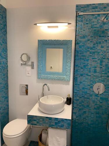 a bathroom with a sink and a toilet and a mirror at Perla Hvar ApartHotel in Ivan Dolac