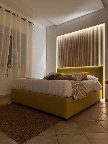 a bedroom with a bed with a yellow headboard at VulcanHome in Cercola