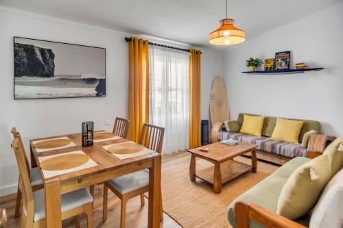 a living room with a table and a couch at Mola Mola Sagres in Sagres