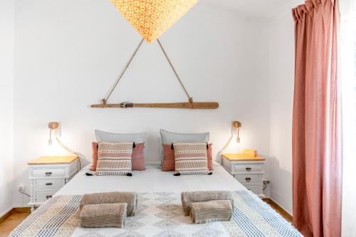a bedroom with a white bed with pillows at Mola Mola Sagres in Sagres
