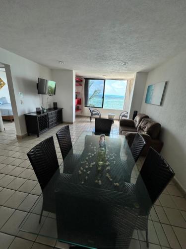 a living room with a couch and a table and chairs at Hermoso departamento frente al mar vista increíble in Cancún