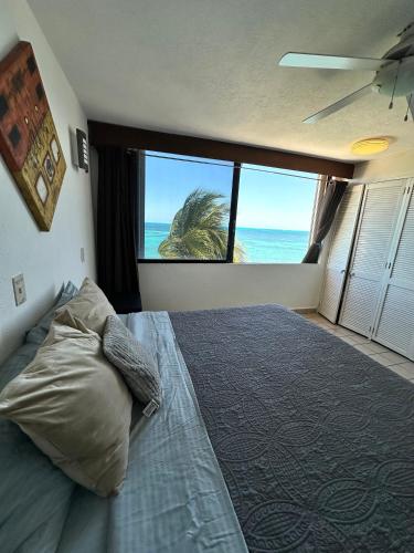 a bedroom with a bed with a view of the ocean at Hermoso departamento frente al mar vista increíble in Cancún