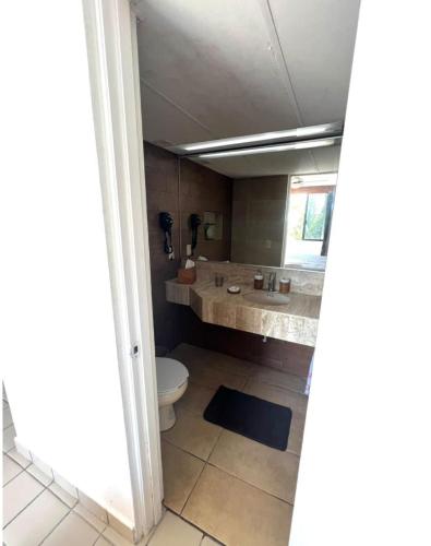 a bathroom with a toilet and a sink at Hermoso departamento frente al mar vista increíble in Cancún