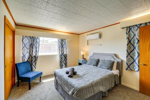 a bedroom with a bed and a blue chair at Walkable Townhome M on Main in Wytheville in Wytheville