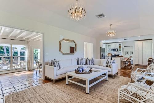 a living room with a white couch and a table at The Glenn House - Gather Poolside in a Breezy South End Getaway in West Palm Beach