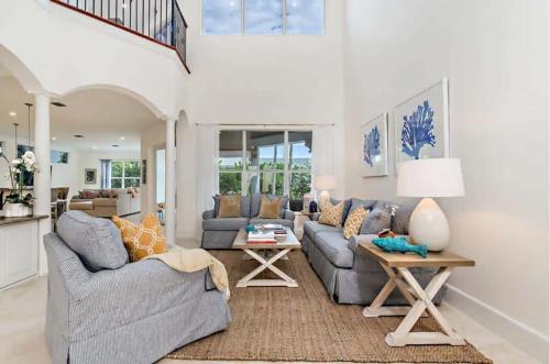 a living room with two couches and a table at Gregory Place - Dine Alfresco by the Pool in South End Sophistication in West Palm Beach