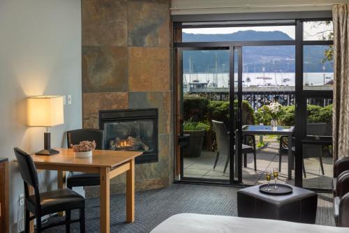 a living room with a fireplace and a table at Brentwood Bay Resort & Spa in Brentwood Bay