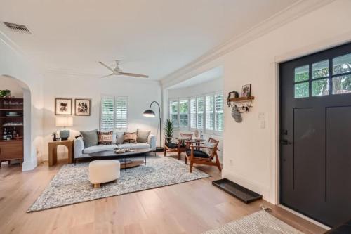 een woonkamer met een bank en een tafel bij Northwood Haven - Light-Filled Bungalow Close to Rybovich Marina in West Palm Beach