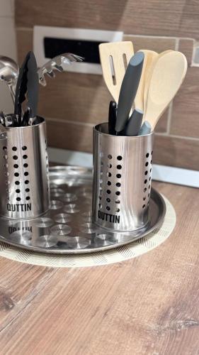 two metal containers filled with utensils on a counter at Green House in Naples