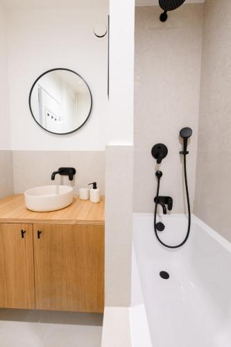 une salle de bain avec un lavabo et un miroir dans l'établissement We Parisian Vanneau Cozy Home, à Paris