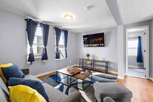 a living room with a couch and a table at Peaceful Hideaway - NYC & NWK with free parking in Newark