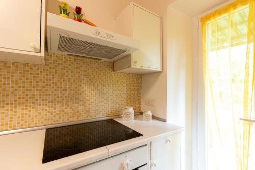 a kitchen with white cabinets and a window at casa minnie in San Marcello Pistoiese
