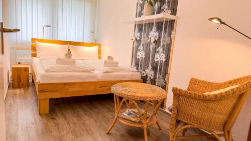 a bedroom with a bed and a chair and a table at Frische-Brise-07-03 in Cuxhaven