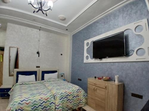 a bedroom with a bed and a flat screen tv on the wall at Ryan S1et Ryan S2 in Fès