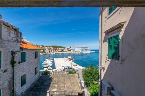 a view of a harbor from between two buildings at Apartment Ljerka in Postira