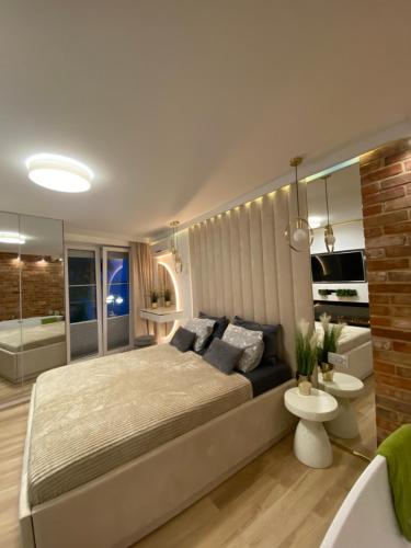 a bedroom with a large bed and a bathroom at Apartament MoLoo I in Ostróda