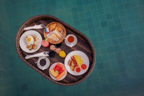 Una bandeja de comida con huevos y fruta encima. en Sila Living Ubud, en Sukawati