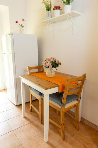 a dining room table with two chairs and a refrigerator at casa minnie in San Marcello Pistoiese