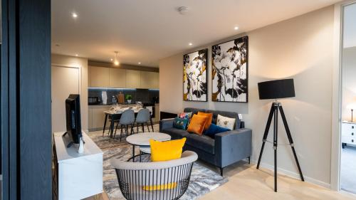 a living room with a blue couch and a tv at Mega5 Modern 2Bedroom Luxury Apartment Deansgate-2baths, 2toilets, with car park in Manchester