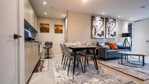 a dining room and living room with a table and a couch at Mega5 Modern 2Bedroom Luxury Apartment Deansgate-2baths, 2toilets, with car park in Manchester