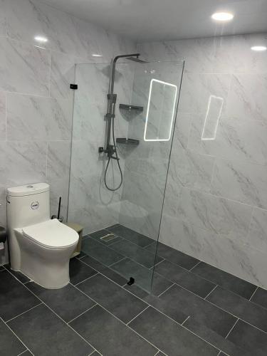 a bathroom with a toilet and a glass shower at Residencial JL Francia II in Ensanche Savica de Mendoza