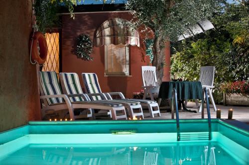 a group of chairs sitting next to a swimming pool at Hotel Castello S. Antonio in Lazise