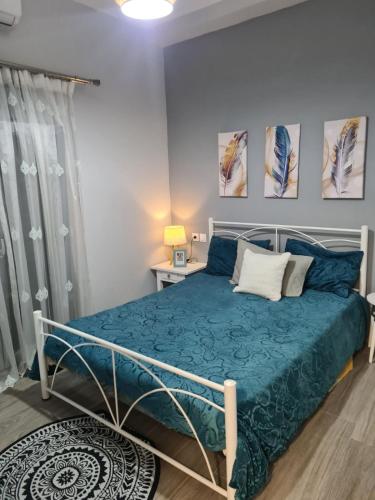 a bedroom with a bed with a blue bedspread at Amyrissa House in Mesochórion