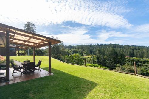 a patio with a table and chairs on a lawn at Whispering Pines Cottages in Burnt Pine